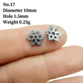 Detailed view of silver flower alloy spacer bead held by hand, 10mm diameter with relief texture - 17#
