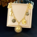 Vintage vergoldete Halskette mit Sonnenmaske und Stiefeln auf einer beigen Box - Vintage Gold Multi-Charm Stil (N3913)
