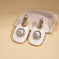 Dettaglio di orecchini placcati oro con smalto bianco e cristalli scintillanti - Orecchini Perno Argento - Bianco / Bianco/Oro