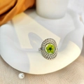 Vue macro d'une bague argentée avec dôme en résine et détail de fleur séchée verte - Ouvert Réglable / Argent avec fleur verte