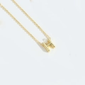Minimalist golden H-letter pendant necklace with a fine cross chain on a white background - Letter H