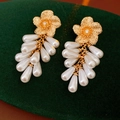 Macro detail of floral gold earrings with zircon centers and white pearl tassels on velvet - Silver Pin-Gold-White