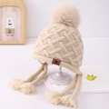 Dettaglio del cappello in maglia beige per neonati con pompon e paraorecchie a treccia - Bambini Grandi 3-8 Anni / Beige