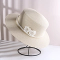 Creamy beige straw sun hat with white pearls and delicate floral accents on a stand - Double Flower Pearl Flat Top Straw Hat Beige