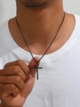 Close-up van een man met een strakke zwarte roestvrijstalen kruis hanger ketting - Zwart