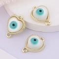 Close-up of three heart-shaped evil eye charms with gold frames and white shell inlays - Heart Border (Double Link)