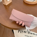 Elegante lange rosa PU-Leder Clutch Geldbörse auf einem Holztisch mit Lifestyle-Requisiten - Rosa