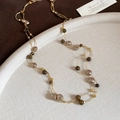 Détail d'un collier à perles œil de tigre superposé sur un plateau vintage - Or-Café (Plaqué Or)