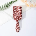 Detail view of red leopard print air cushion hairbrush with black bristles on white backdrop - Reddish Brown Leopard