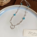 Detailed view of beaded necklace with blue glass cubes and a clear heart pendant charm - Silver Chain Blue Heart Necklace
