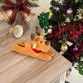 Dettaglio di una renna di peluche con sciarpa rossa su superficie in legno festiva - Alce