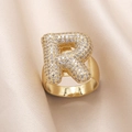 Gold plated ring with sparkling zircon letter R on smooth beige silk fabric - Small / Letter R
