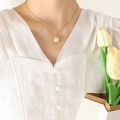 Golden geometric textured necklace with baroque pearl pendant shown on a model - Gold