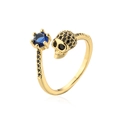 Dettaglio macro dell'anello con teschio, zircone blu e pavé di pietre nere - Teschio con pietra blu rotonda(13117) / Oro-Zirconia Blu
