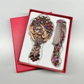 Detailed view of vintage bronze peacock hand mirror and comb set inside a red gift box - Double Peacock (No. 2) / Red Copper