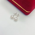 Macro view of white freshwater pearl earrings with S925 silver studs on white leather - 7mm