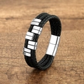 Bracciale in pelle nera intrecciata con ciondoli d'argento su fondo in legno rustico - Bianco