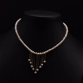 Natural pearl necklace featuring a golden tassel pendant on a black mannequin display - Tassel Artificial Pearl Necklace Style