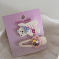 Détail de pinces à cheveux ours et tulipe sur carte rose avec fond texturé blanc épuré - Ours Appareil Photo