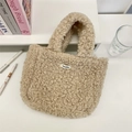 Bolso de mano de peluche beige con accesorios de moda sobre un fondo blanco limpio - Caqui