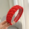 Detail of red braided fabric headband showing inner plastic teeth and woven texture - Red