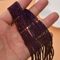 Macro shot of dark purple faceted crystal glass beads held by hand for jewelry DIY - Phantom Purple