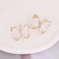 Elegant gold butterfly earrings with sparkling cubic zirconia on a white display tray - White
