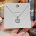 Silver butterfly necklace with blue iridescent inlay and white zircon details on card - X755 Silver Iridescent Butterfly
