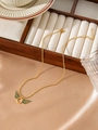 Golden bead necklace with green gemstone wing pendant on a jewelry display box - Zhn593 Green