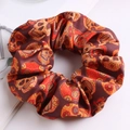 Detail of fabric scrunchie featuring red and orange sugar skull and floral patterns - Orange Skull