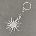 Details von Vintage Sonne- und Mond-Schlüsselanhänger in Silber auf Betonhintergrund-Struktur - Antiksilber Sonne