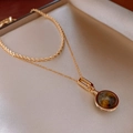 Dettaglio ravvicinato della collana a strati dorata con ciondolo in pietra occhio di tigre - Collana - Oro (Placcato Oro)