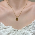 Detailed close-up of a vintage tiger eye beaded layered necklace with a gold circular pendant - Gold Necklace Round Dark Pendant Style (9735)