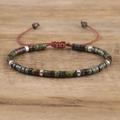 Macro detail of natural stone beads and silver spacers on handmade woven bracelet - No.16 Dragon Blood Stone