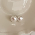 Détail macro de boucles d'oreilles perles 14mm sur un plat en céramique crème - Style Clou 14mm (MY35425)