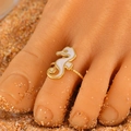 Adjustable golden seahorse toe ring with white enamel detail on sandy beach - White Seahorse (12259)