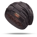 Dettaglio del cappello in maglia marrone con fodera in pile e etichetta sportiva in pelle - Berretto / caffè