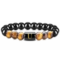 Détail du bracelet en perles d'agate noire, oeil de tigre et breloque lettre U dorée - Lettre U