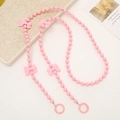 Pink beaded crossbody phone strap with bows and metal rings on a minimalist white tray - Beaded Crossbody / 120cm / Pink
