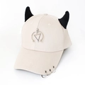 Close-up of cream baseball cap with black 3D devil horns and silver metal ring accents - Triangle Beige