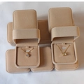 Detail view of premium beige velvet necklace boxes with elegant golden pendants inside - Apricot