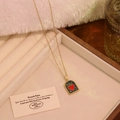 Detalle del colgante de arco vintage con corazón rojo y estrellas de esmalte verde en collar - Verde