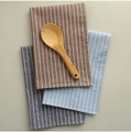 Detail view of striped cotton kitchen towels in brown and blue with a wooden spoon accessory - Striped 3-Piece Set