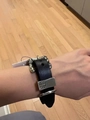 Dettaglio del bracciale in pelle nera con borchie a croce d'argento al polso - Polsino con Borchie e Croce