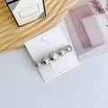 Polished silver metal hair clip with geometric hammered spheres on a display card - Round Silver