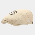 Close-up of beige cotton beret featuring cartoon dog embroidery and Happy Day text - Adjustable / Beige