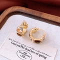 Detail van vintage hars oorringen met vierkante kristallen in champagne en bruine kleur - Maillard Vierkante Diamanten Ring / Goud/Bruin