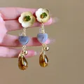 Detail of flower tassel earring with green gemstone, cream petals and amber waterdrop - Amber Bead Patchwork Drop Style / Gold