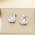 Detail of silver spiral teardrop earrings with white pearl inlay on a soft beige background - Hollow Teardrop Style (KE115916-GC)