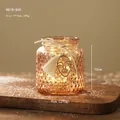 Portacandele natalizio in vetro ambrato con luci LED, nappe bianche e decori in corda - Ambra a Pois (HG18-860)